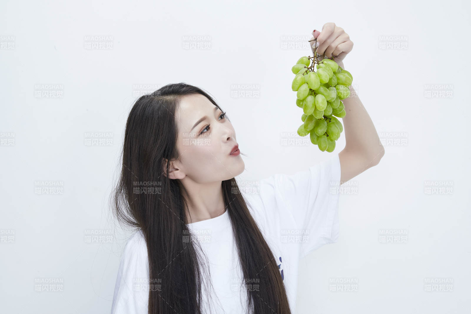 吃葡萄的穿白色長T血衫的長發可愛少女人像