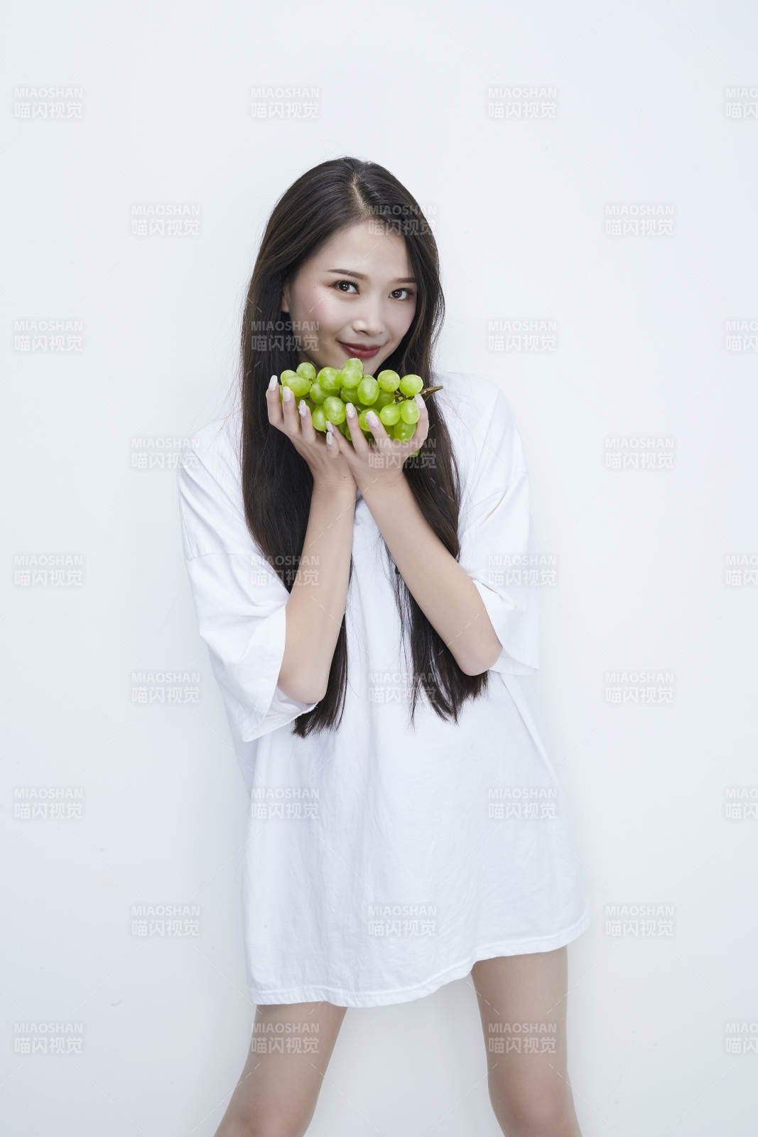 吃葡萄的穿白色長T血衫的長發可愛少女人像