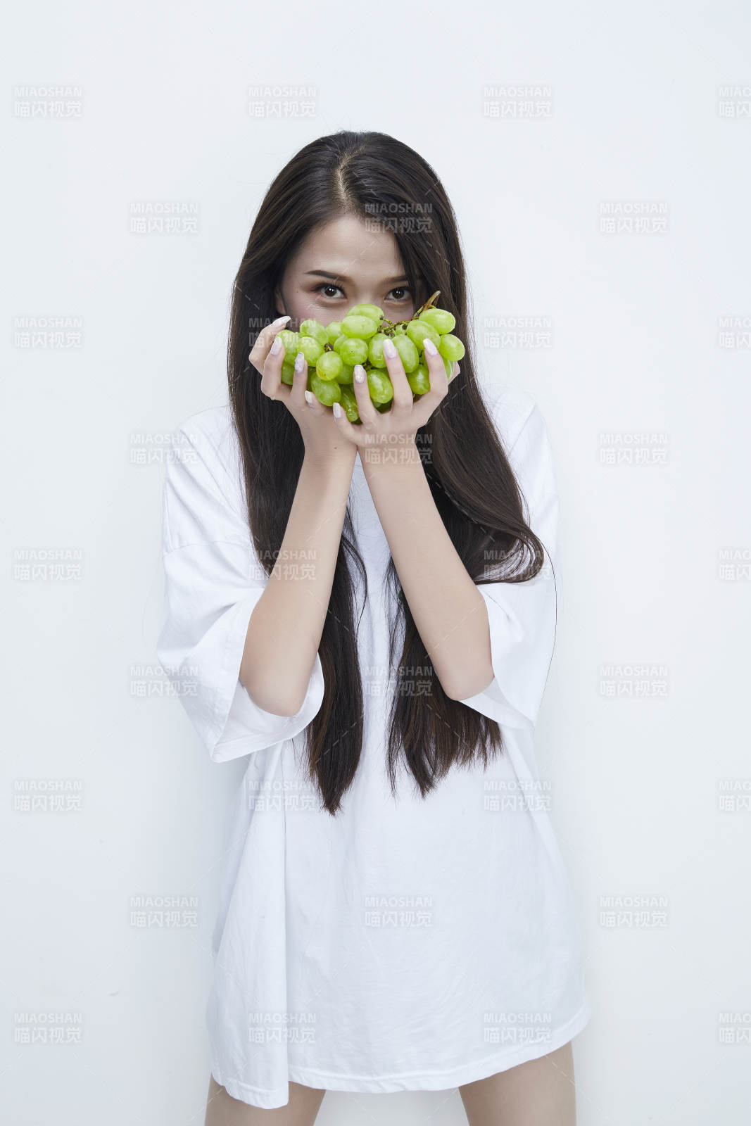 吃葡萄的穿白色長T血衫的長發可愛少女人像