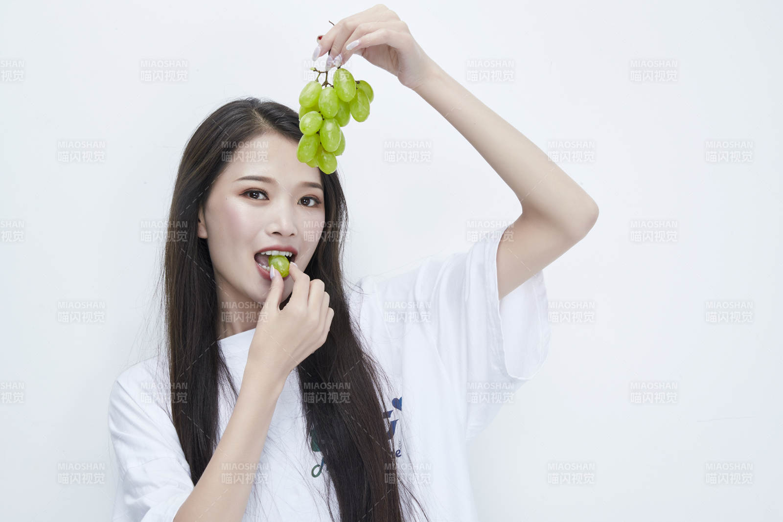 吃葡萄的穿白色長(zhǎng)T血衫的長(zhǎng)發(fā)可愛(ài)少女人像