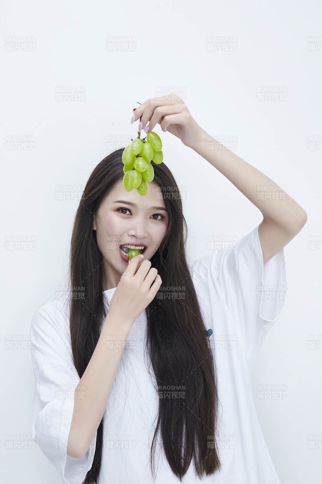 吃葡萄的穿白色長(zhǎng)T血衫的長(zhǎng)發(fā)可愛(ài)少女人像