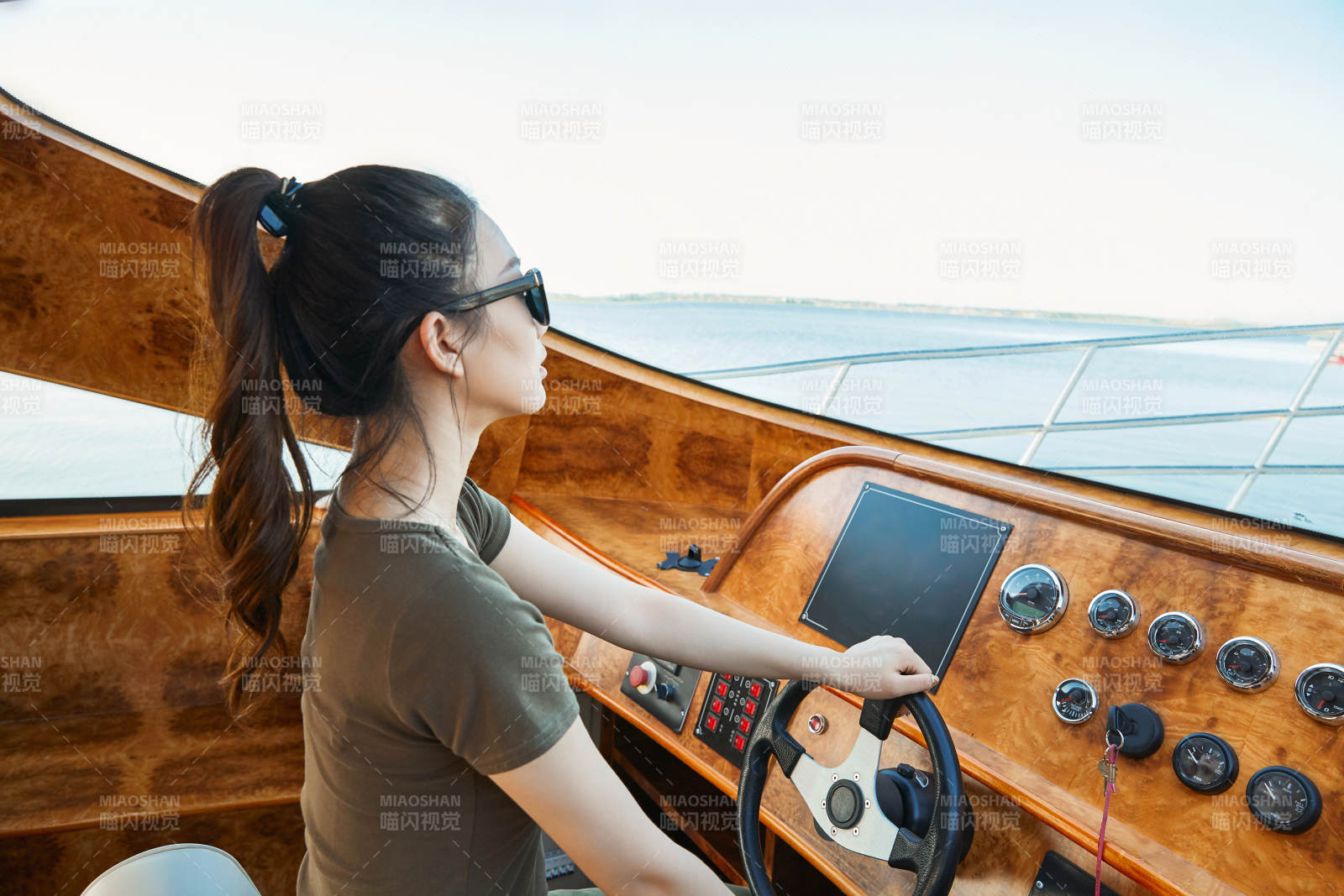 在海上戴著墨鏡駕駛游艇的亞洲少女