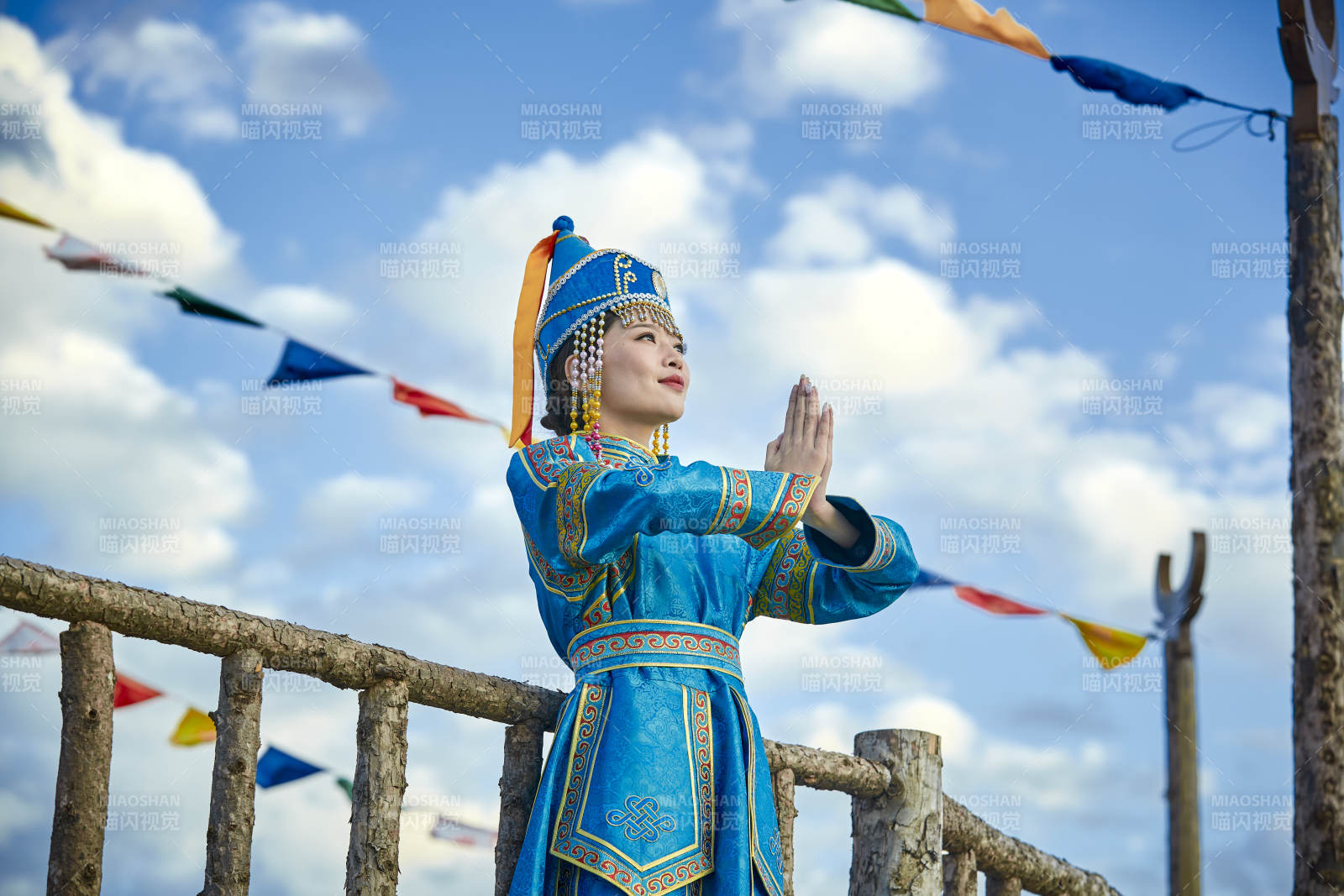 草原上敖包前身穿豪华蒙古族服饰的蒙族少女