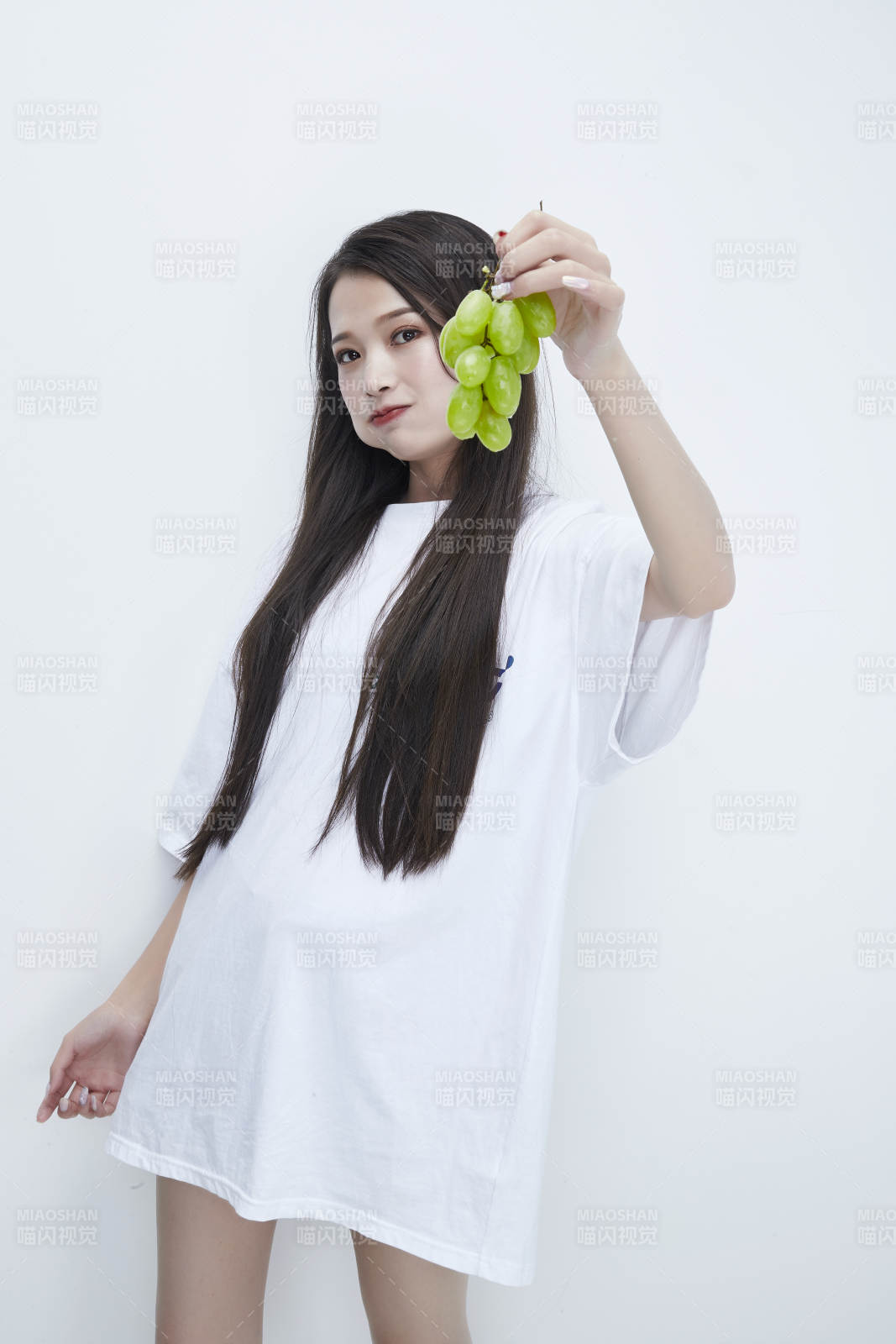 吃葡萄的穿白色長T血衫的長發可愛少女人像