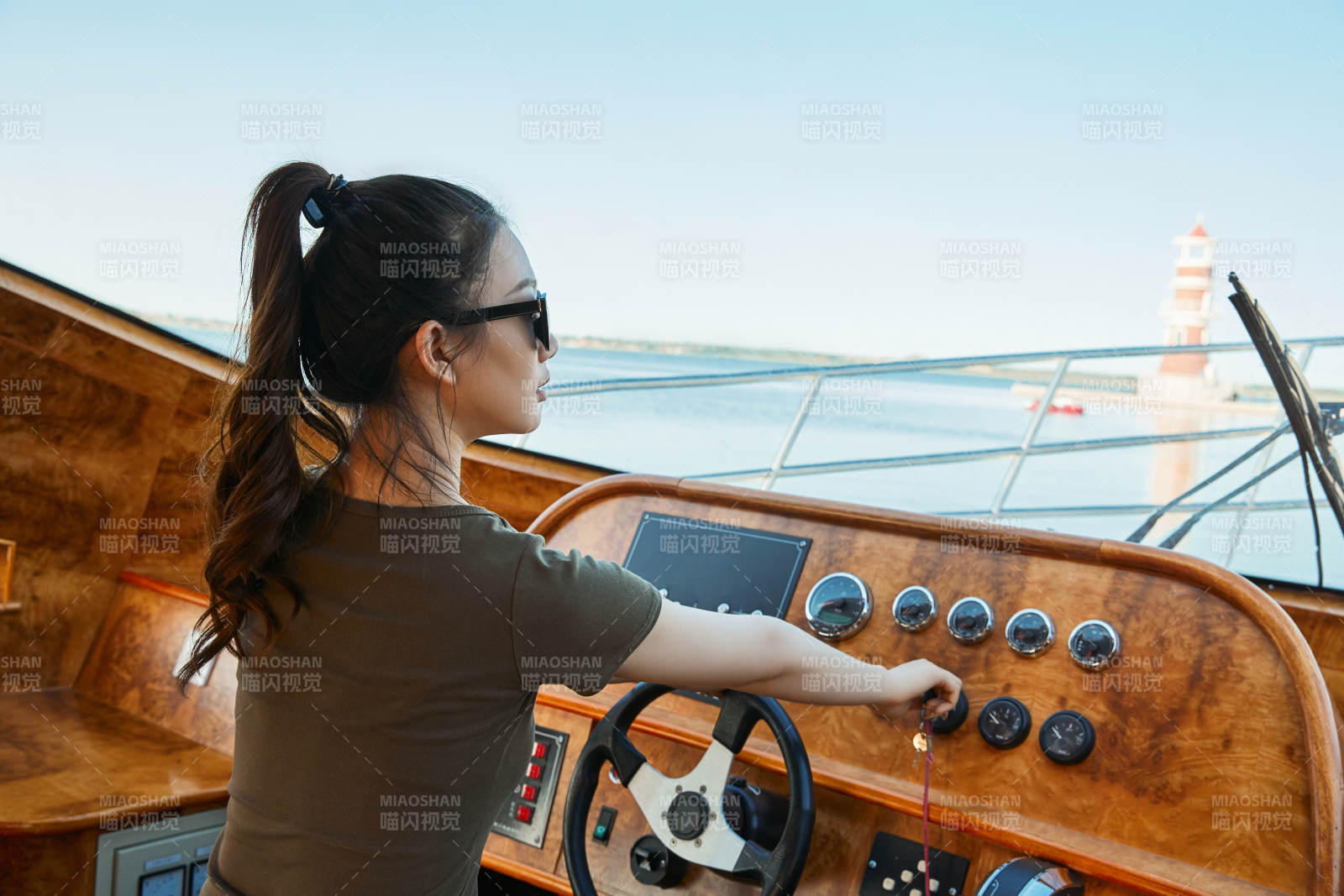 在海上戴著墨鏡駕駛游艇的亞洲少女