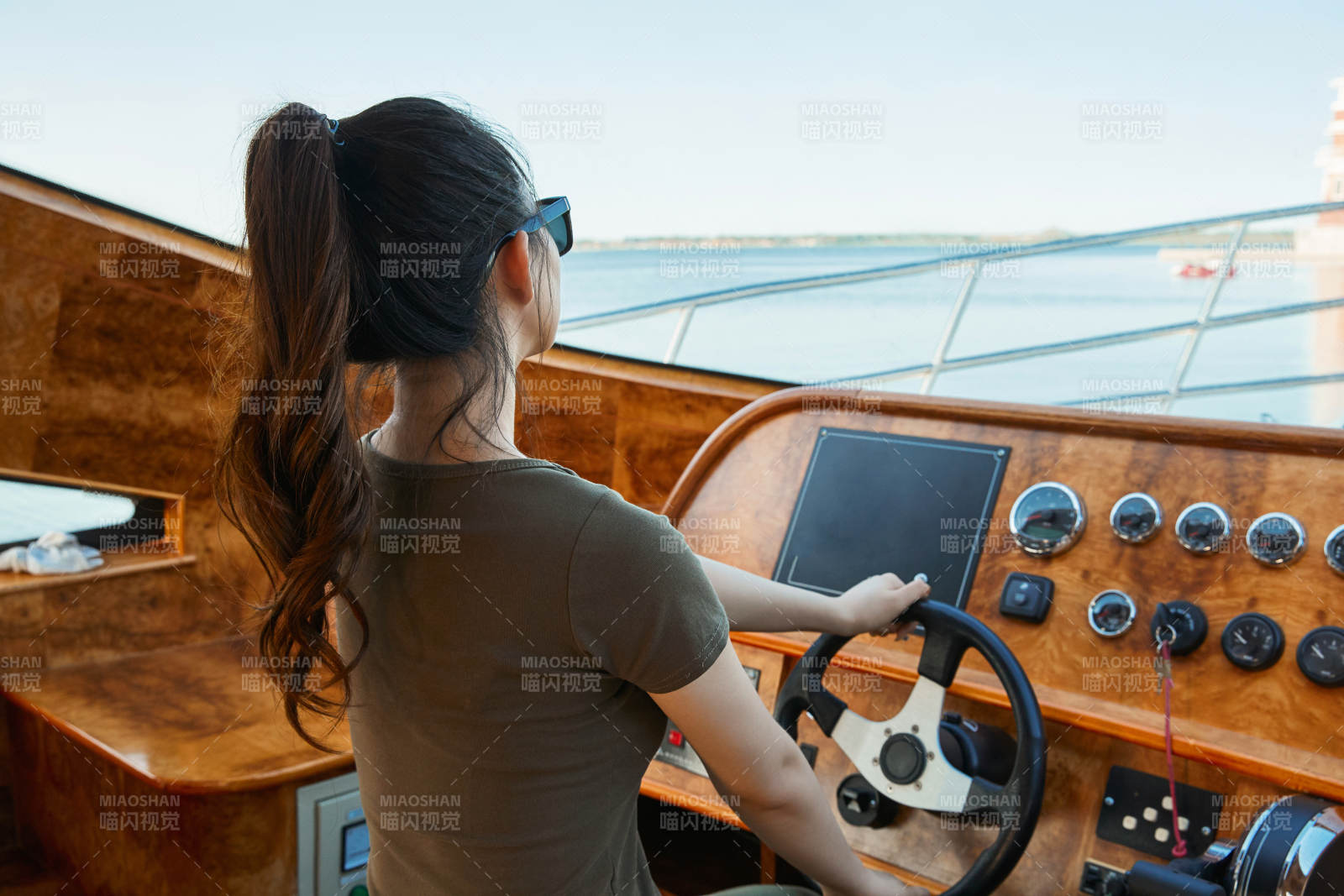 在海上戴著墨鏡駕駛游艇的亞洲少女