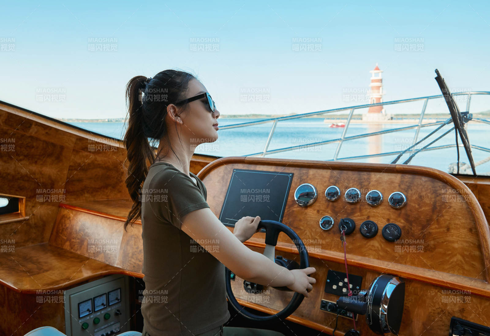 在海上戴著墨鏡駕駛游艇的亞洲少女