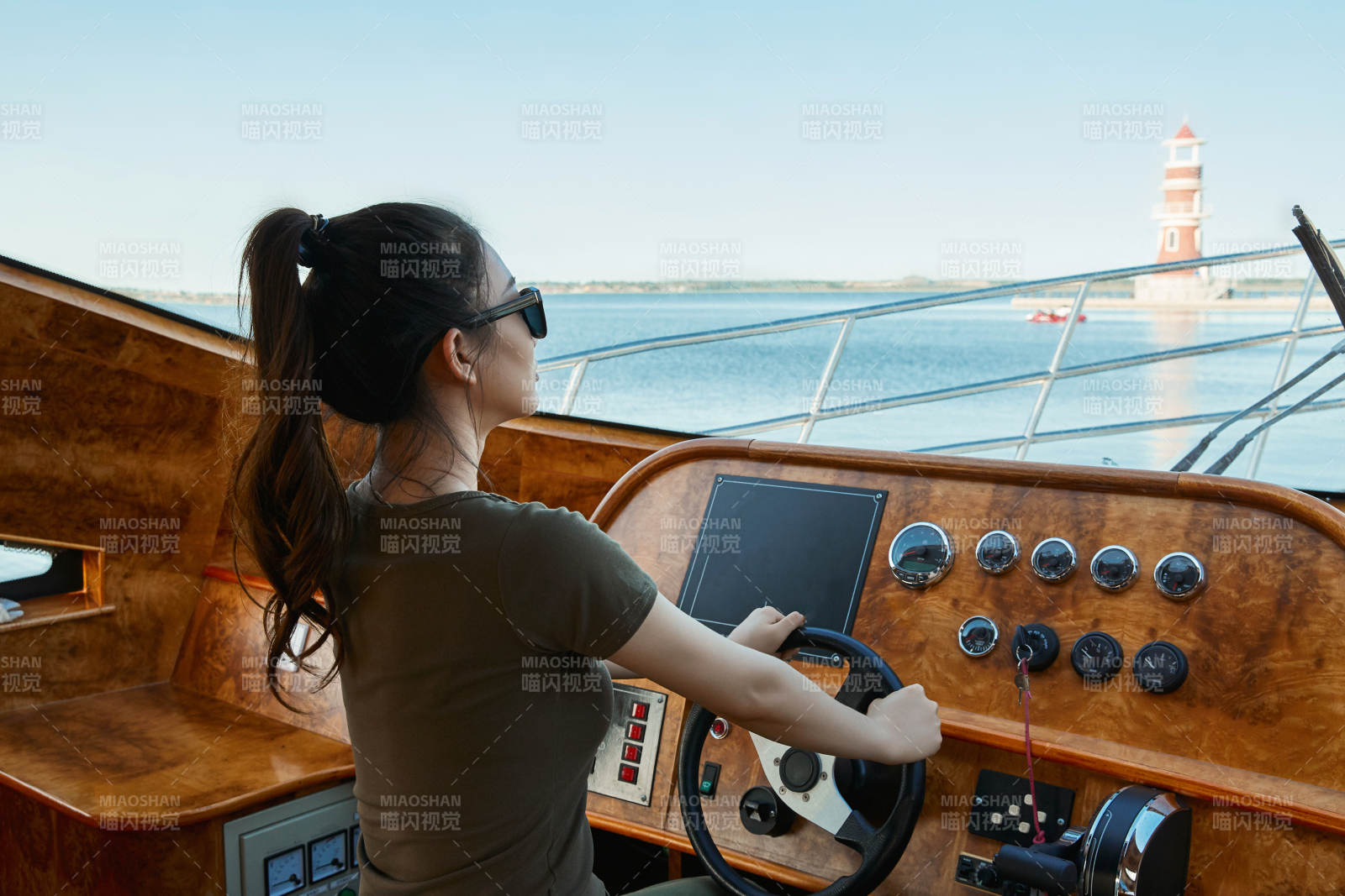 在海上戴著墨鏡駕駛游艇的亞洲少女