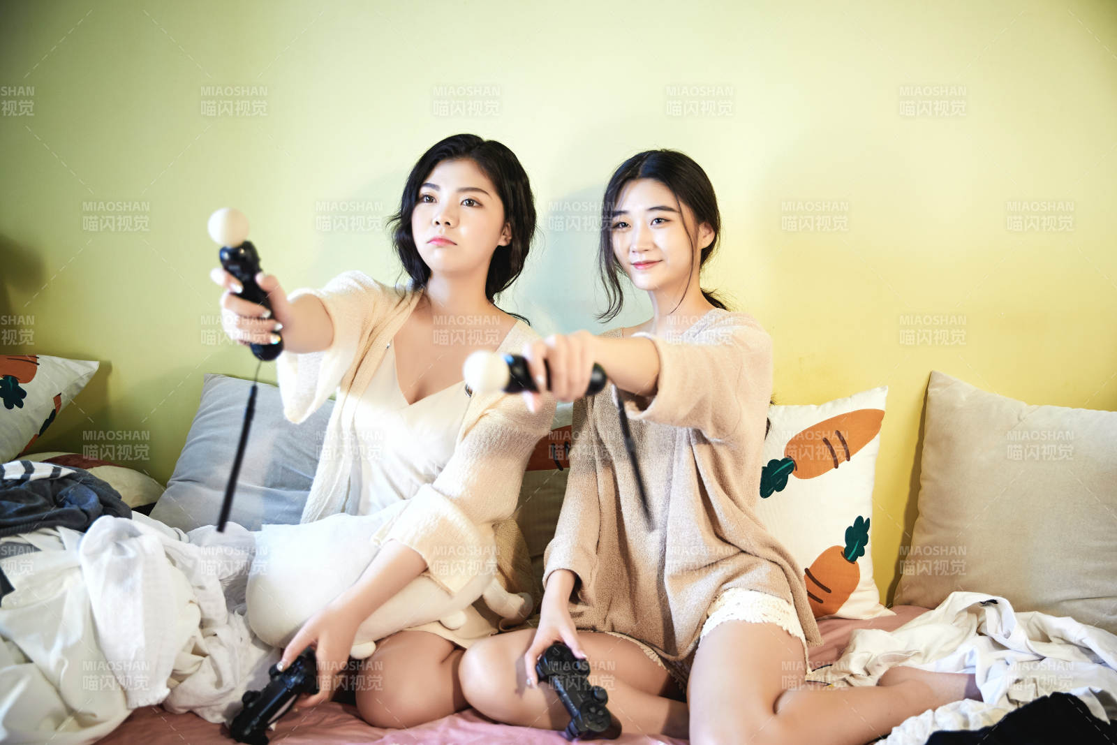 坐在床上打電玩的倆位美女