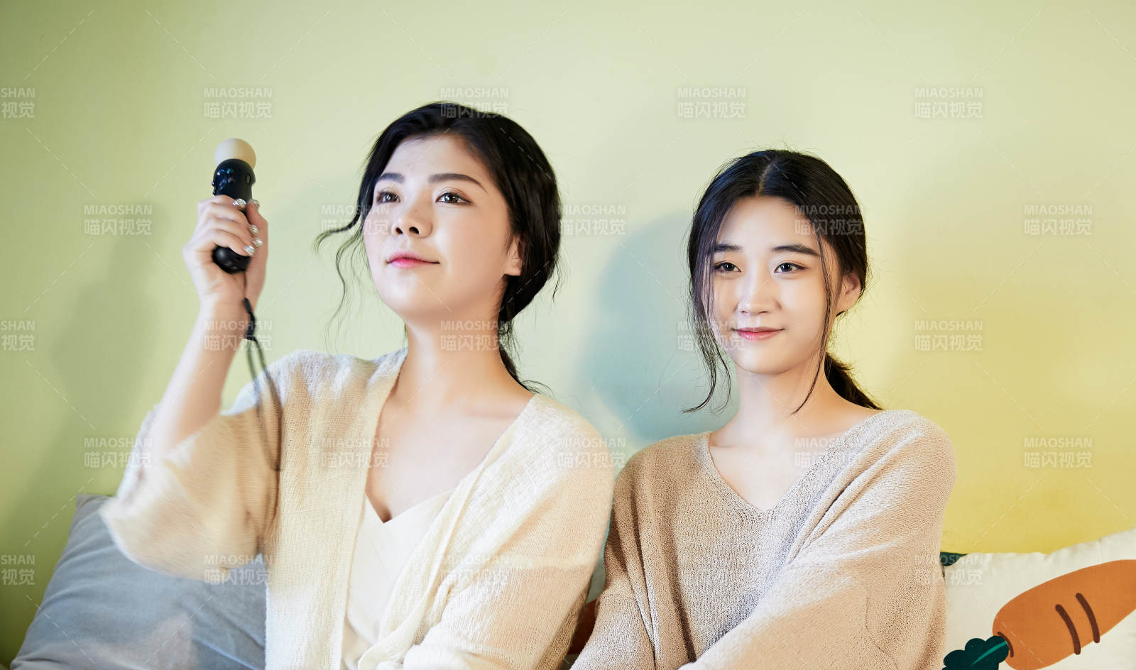 坐在床上打電玩的倆位美女