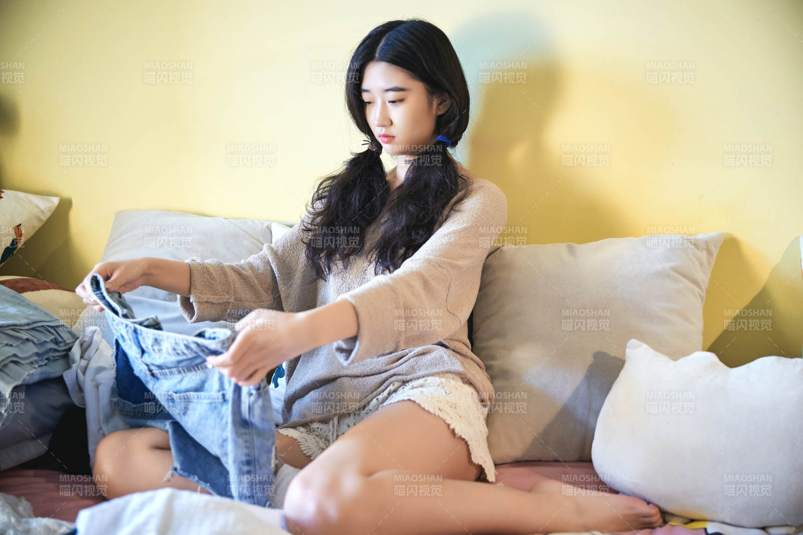 在沙發(fā)床上整理行裝的年輕亞洲女性