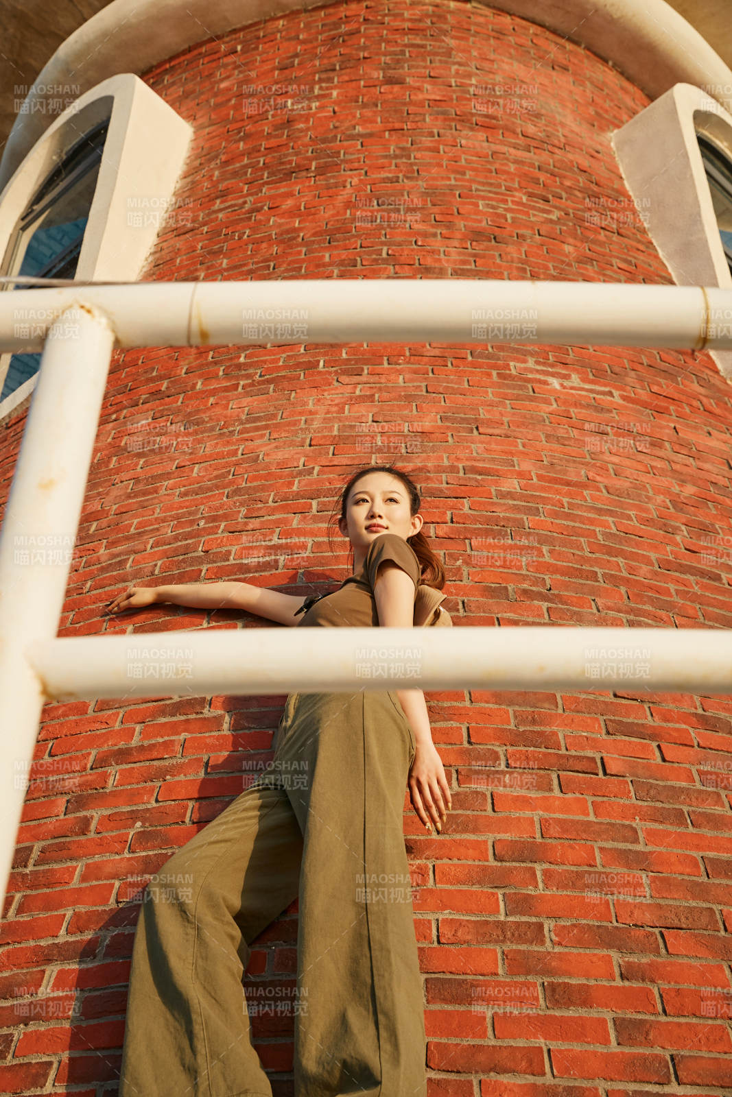 盛夏夕陽晚霞湖邊碼頭燈塔上的少女