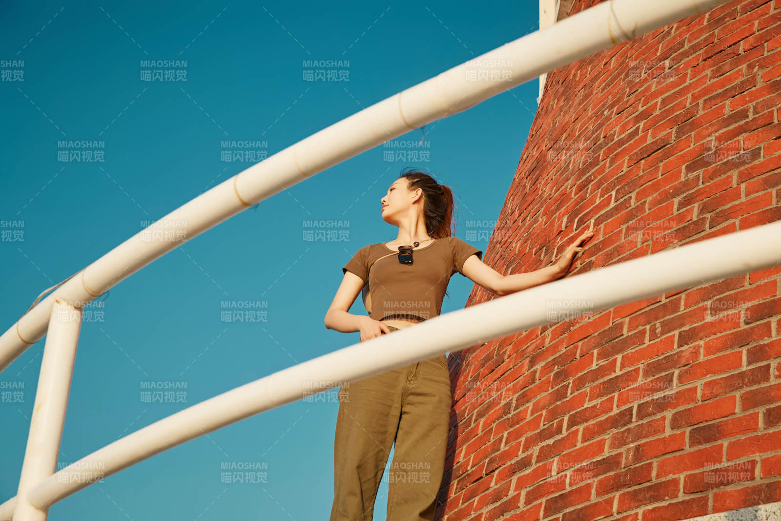 盛夏夕陽晚霞湖邊碼頭燈塔上的少女
