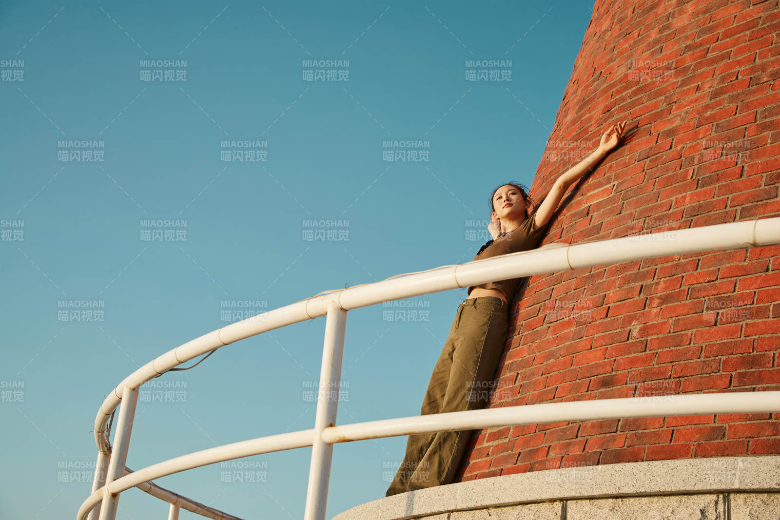盛夏夕陽晚霞湖邊碼頭燈塔上的少女