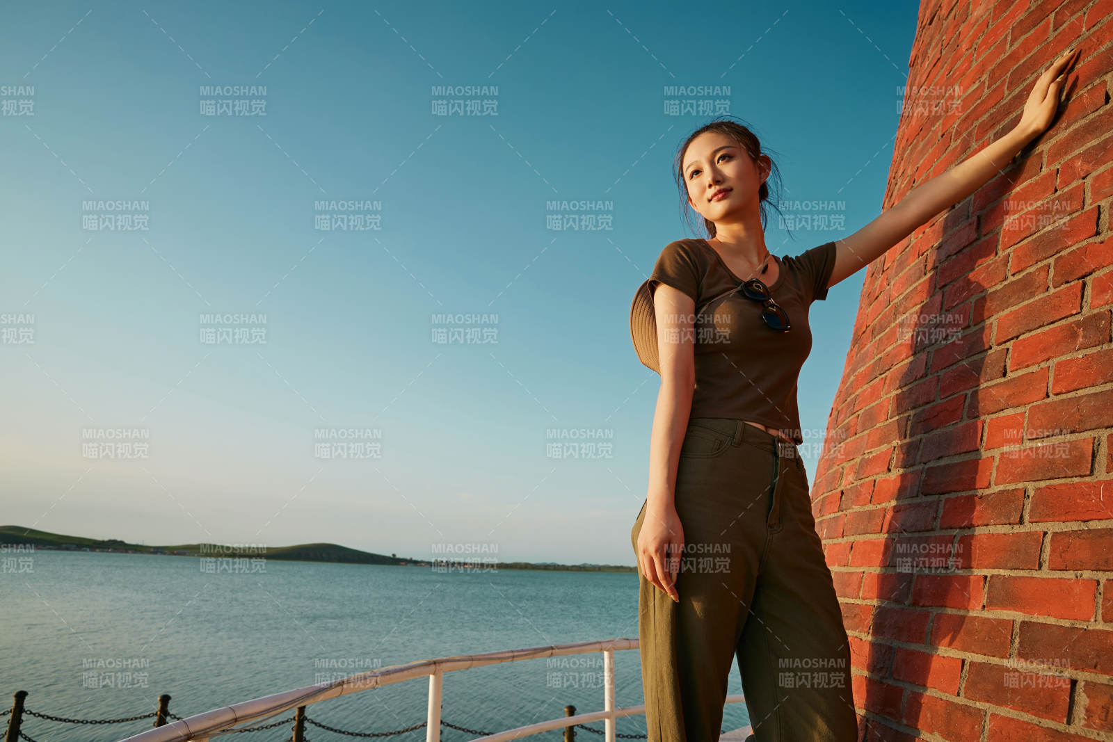 盛夏夕阳晚霞湖边码头灯塔上的少女图片