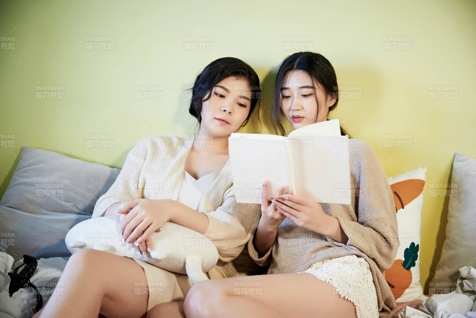 坐在床上讀書的倆位美女