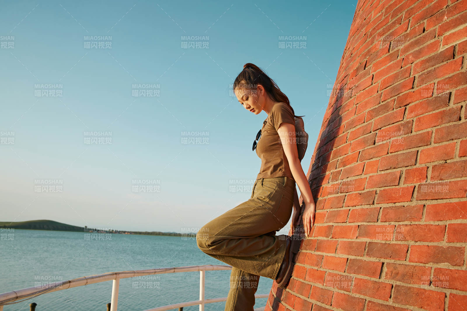 盛夏夕陽晚霞湖邊碼頭燈塔上的少女