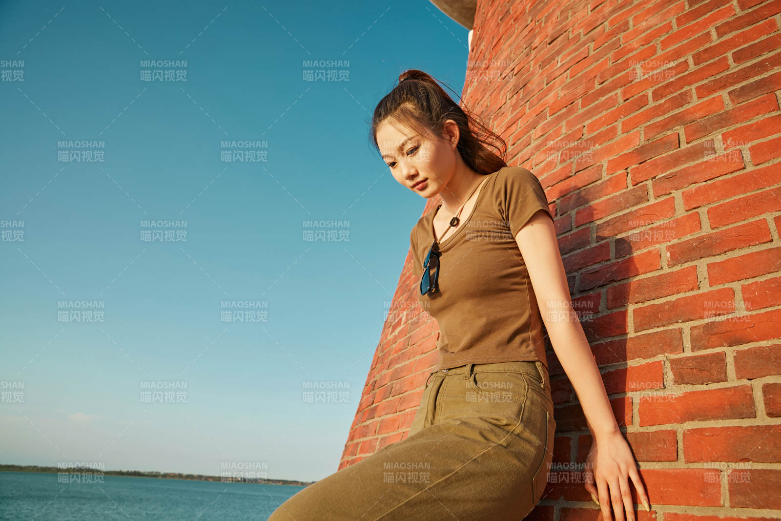 盛夏夕陽晚霞湖邊碼頭燈塔上的少女