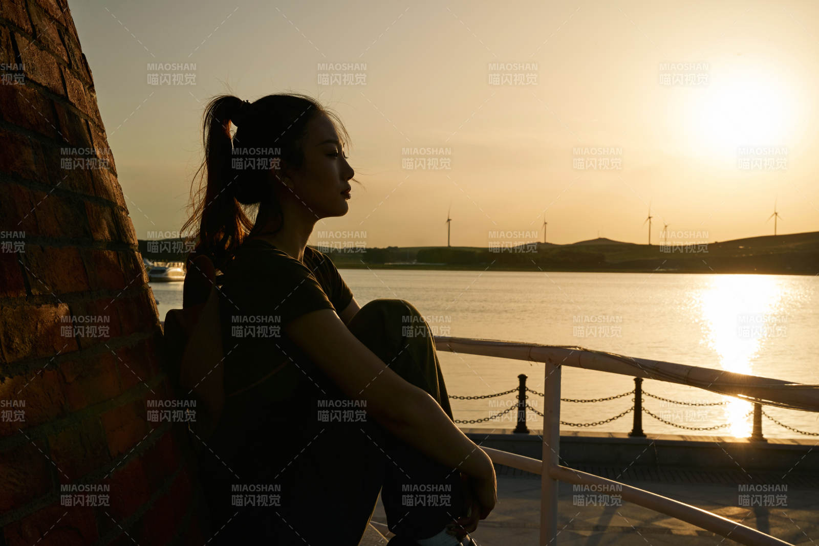 盛夏夕陽晚霞湖邊碼頭燈塔上的少女