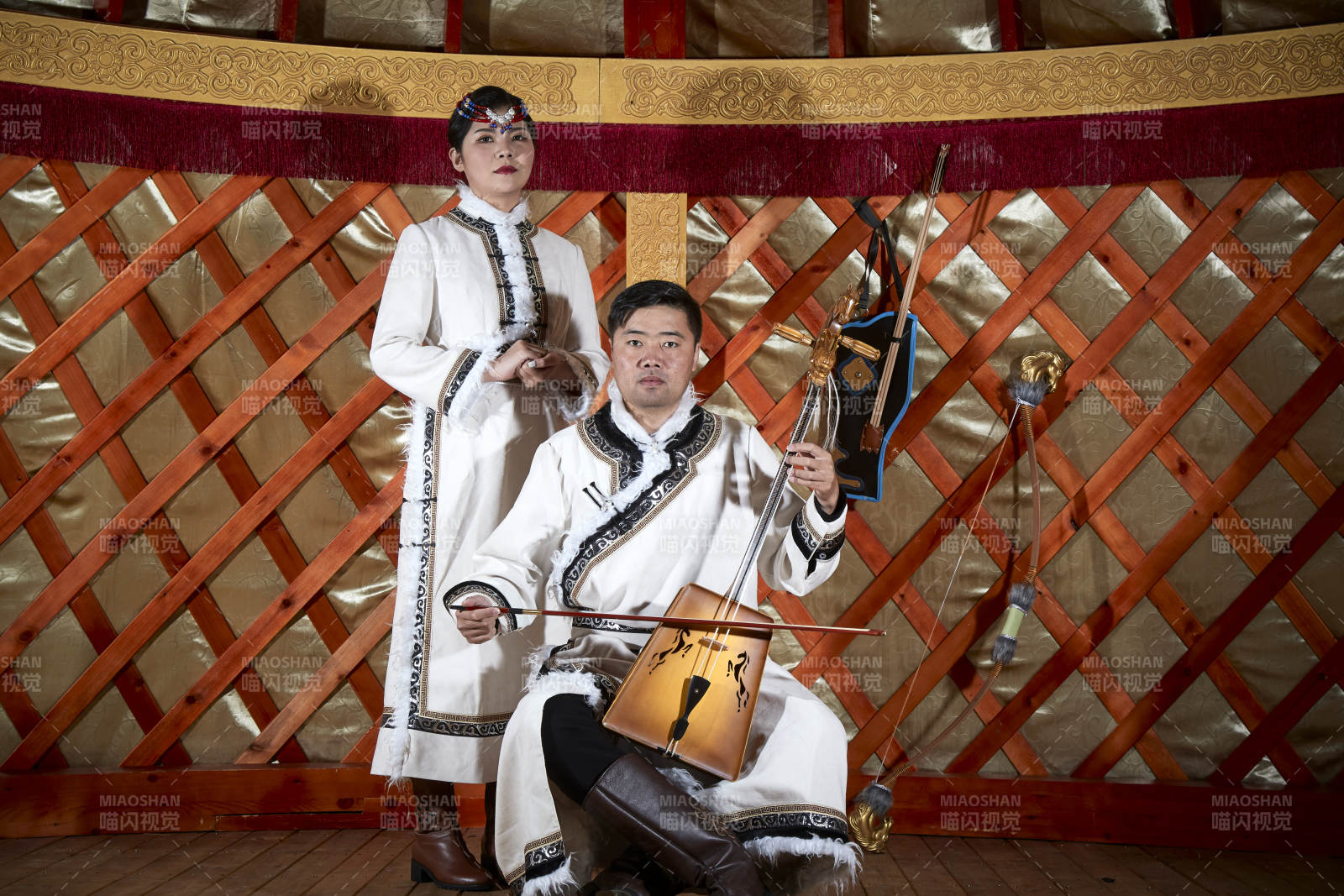 草原上蒙古包里穿蒙古族傳統(tǒng)服飾的年輕夫妻