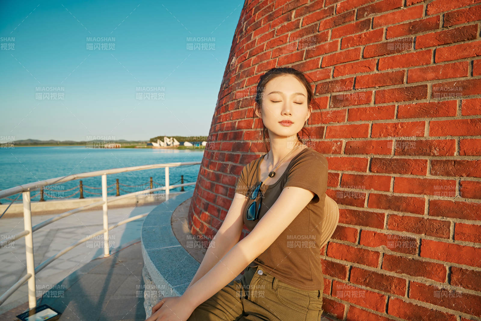 盛夏夕陽晚霞湖邊碼頭燈塔上的少女