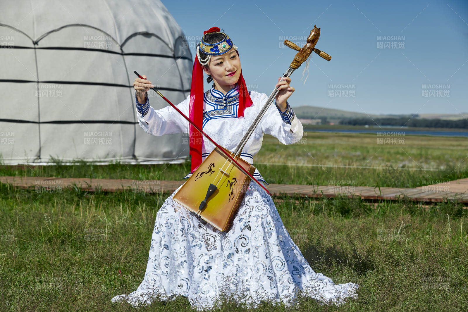 蒙古包前穿蒙古族服飾拉馬頭琴的蒙族女樂手