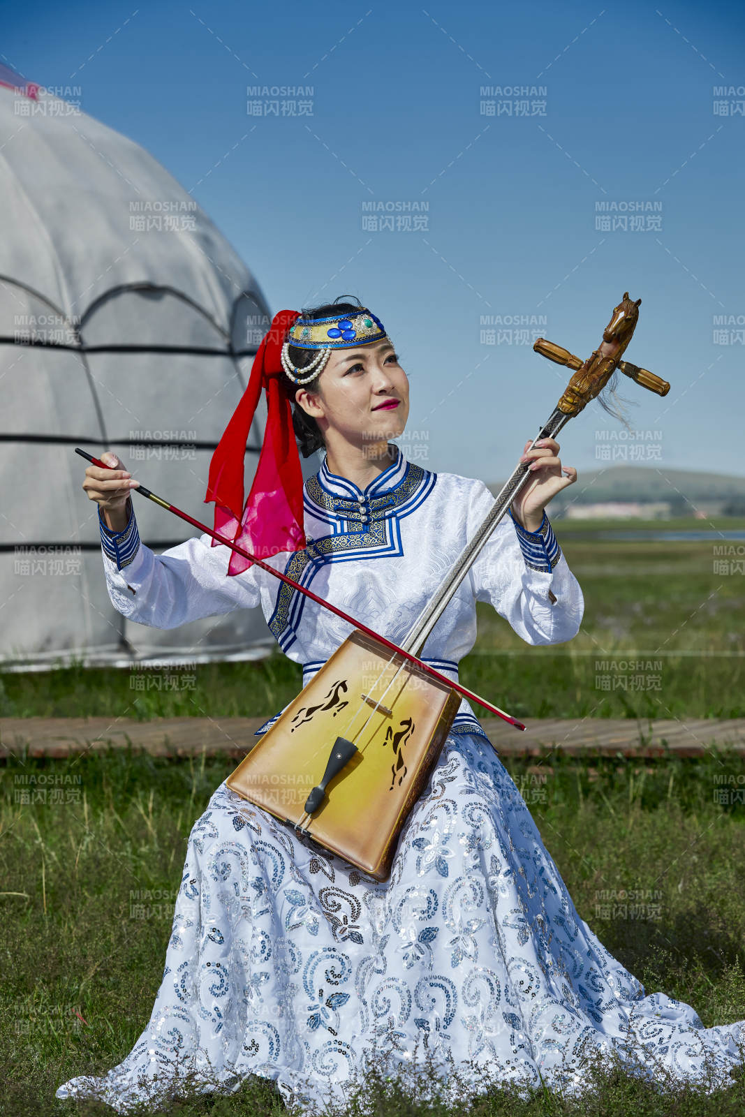 蒙古包前穿蒙古族服饰拉马头琴的蒙族女乐手