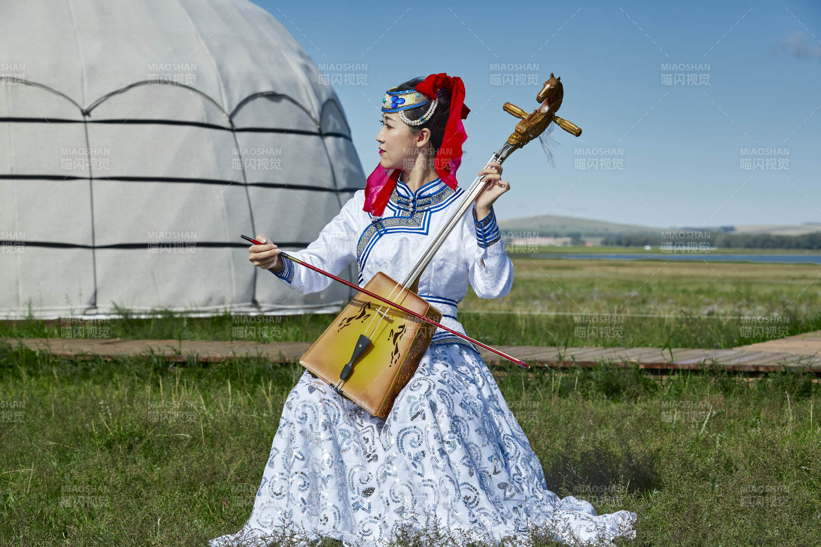 蒙古包前穿蒙古族服飾拉馬頭琴的蒙族女樂手