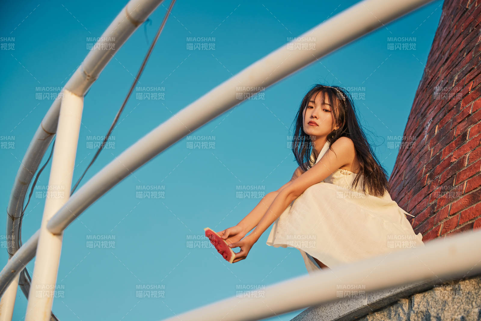 盛夏夕陽湖邊碼頭燈塔上吃西瓜的少女