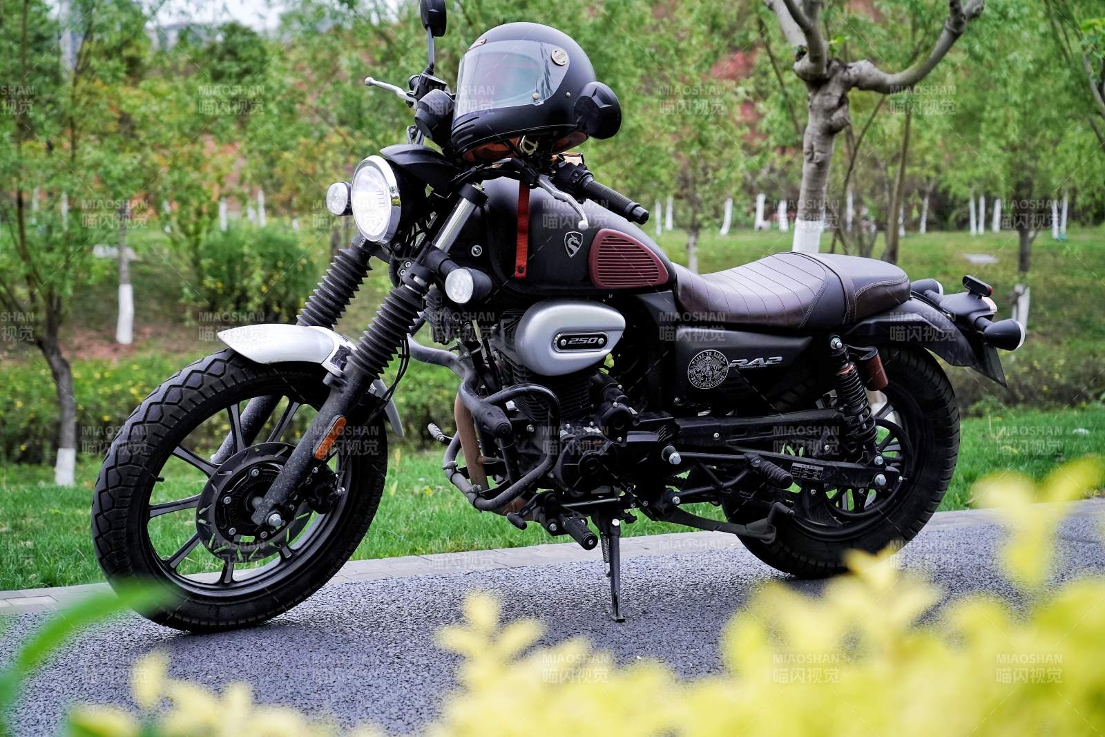 黑色摩托车静停绿意中