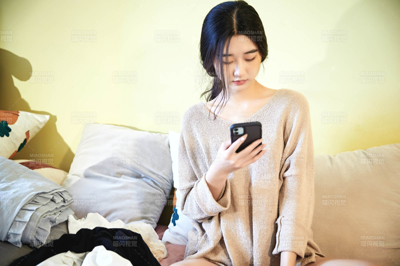 在沙發床上整理行裝的年輕亞洲女性