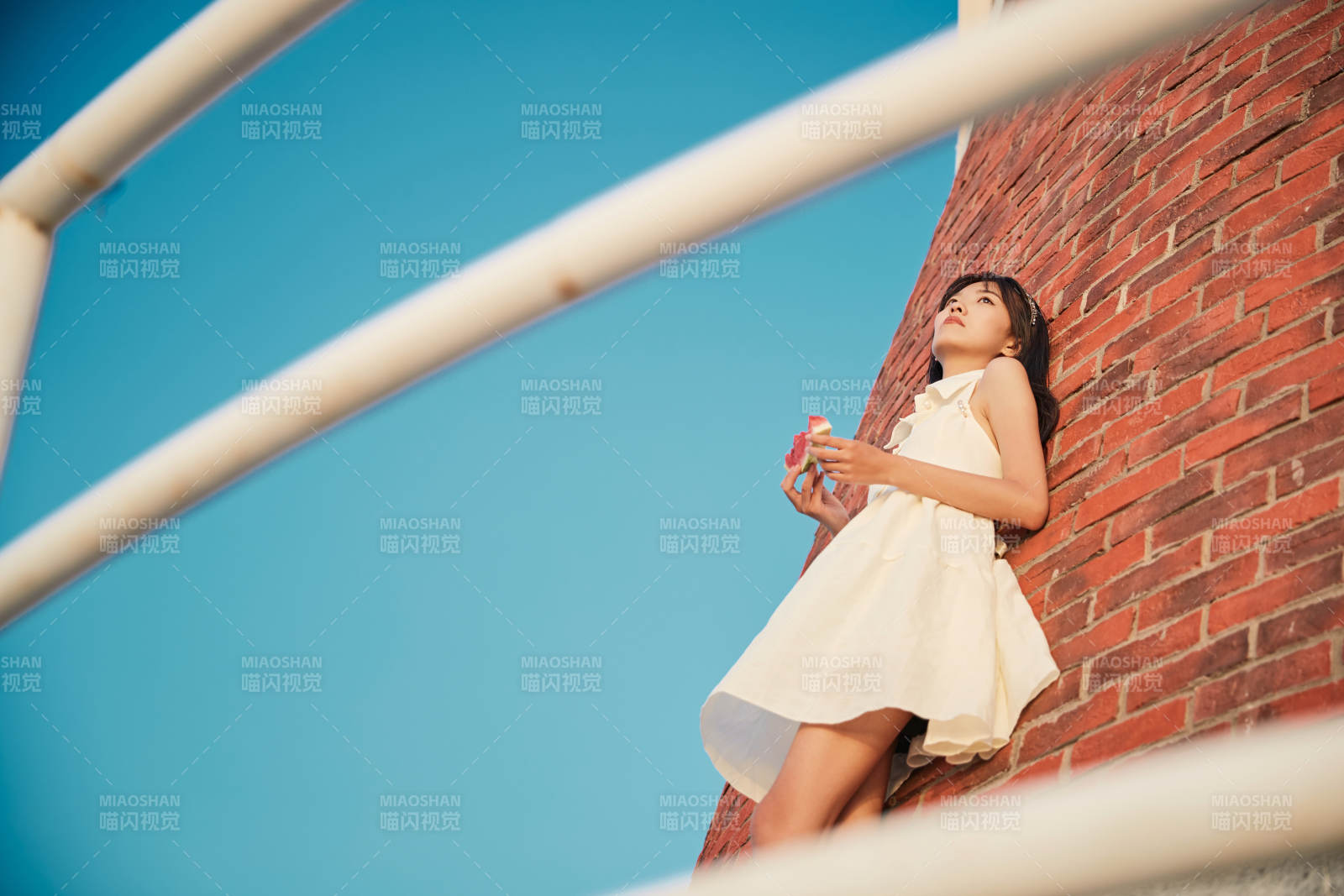 盛夏夕陽湖邊碼頭燈塔上吃西瓜的少女