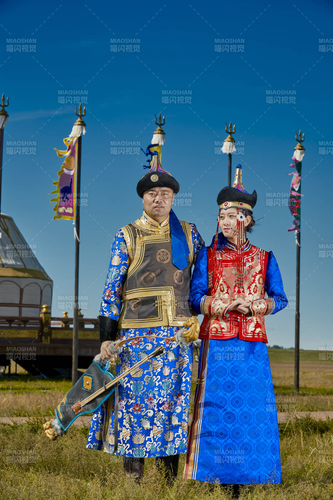 草原上蒙古包前穿蒙古族傳統服飾的年輕夫妻