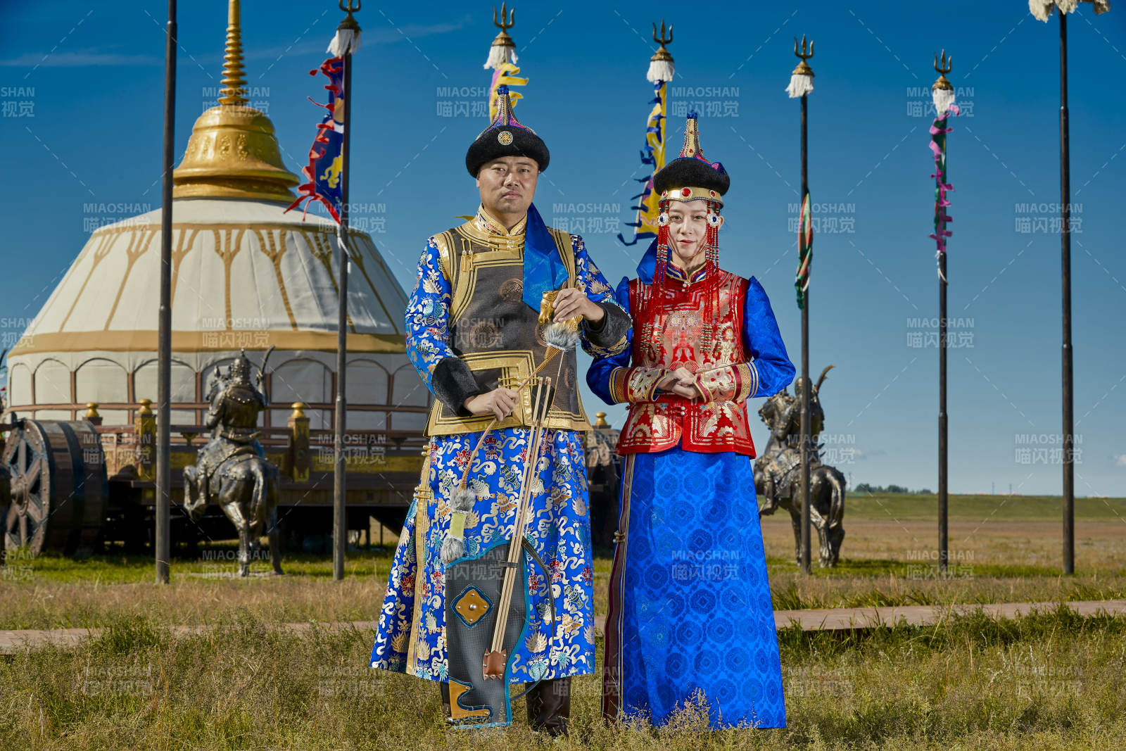 草原上蒙古包前穿蒙古族传统服饰的年轻夫妻