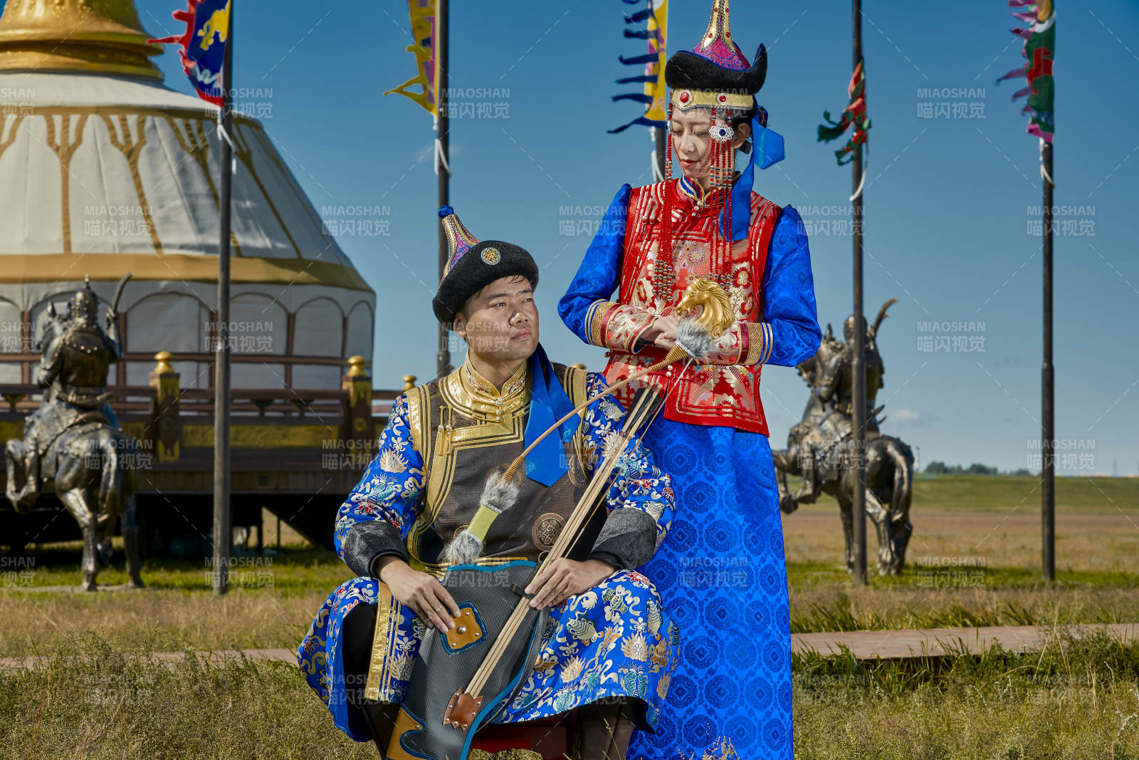 草原上蒙古包前穿蒙古族傳統服飾的年輕夫妻