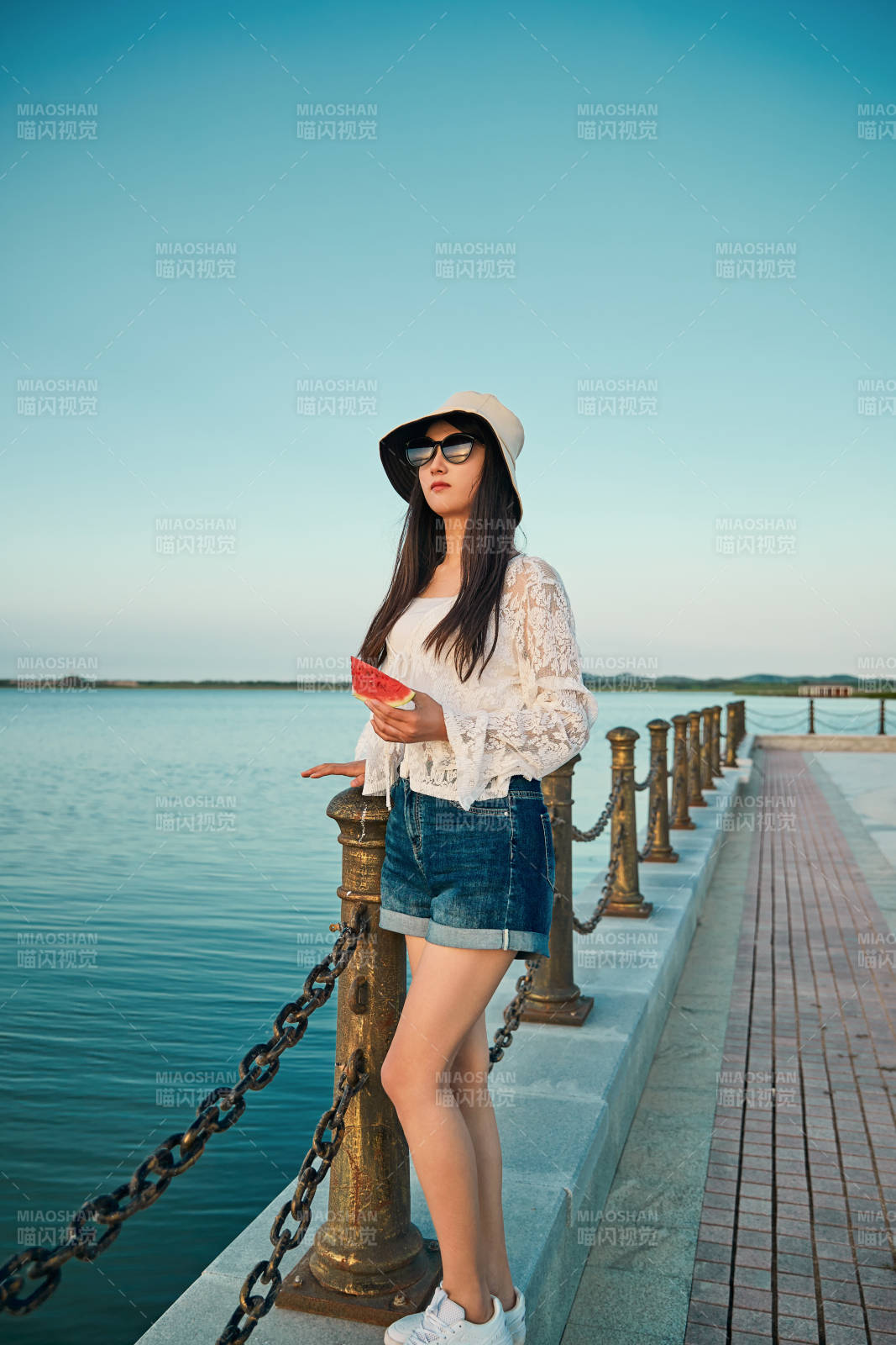 盛夏夕陽晚霞湖邊碼頭看風景的少女