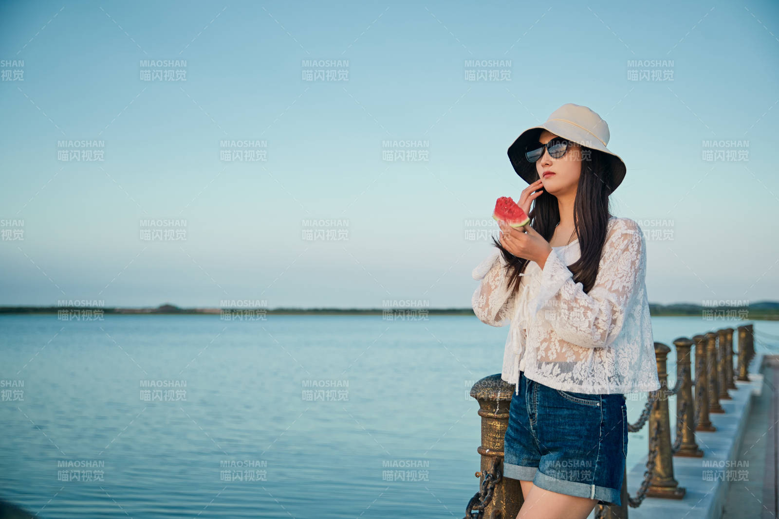 盛夏夕陽晚霞湖邊碼頭看風景的少女
