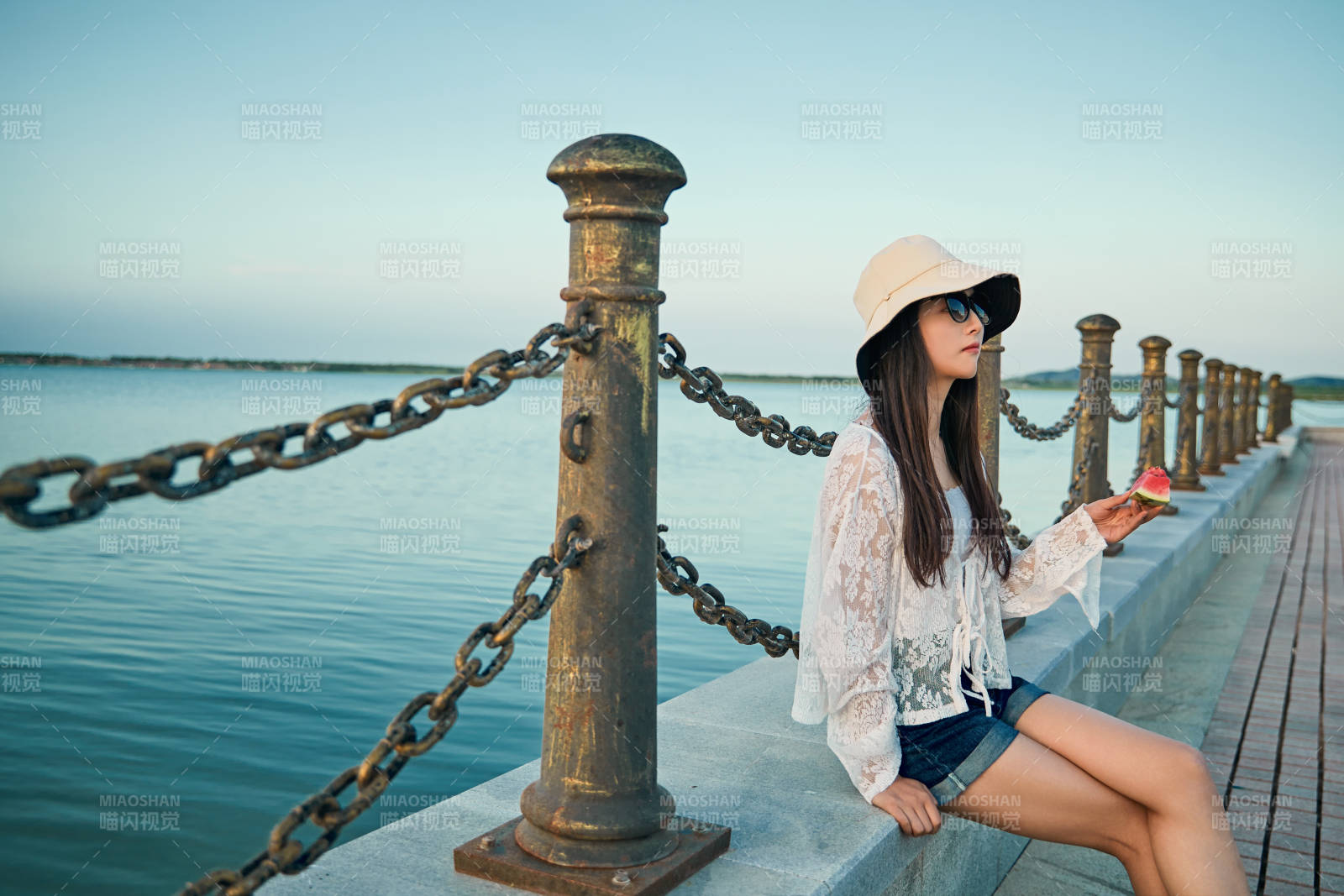 盛夏夕陽晚霞湖邊碼頭看風景的少女