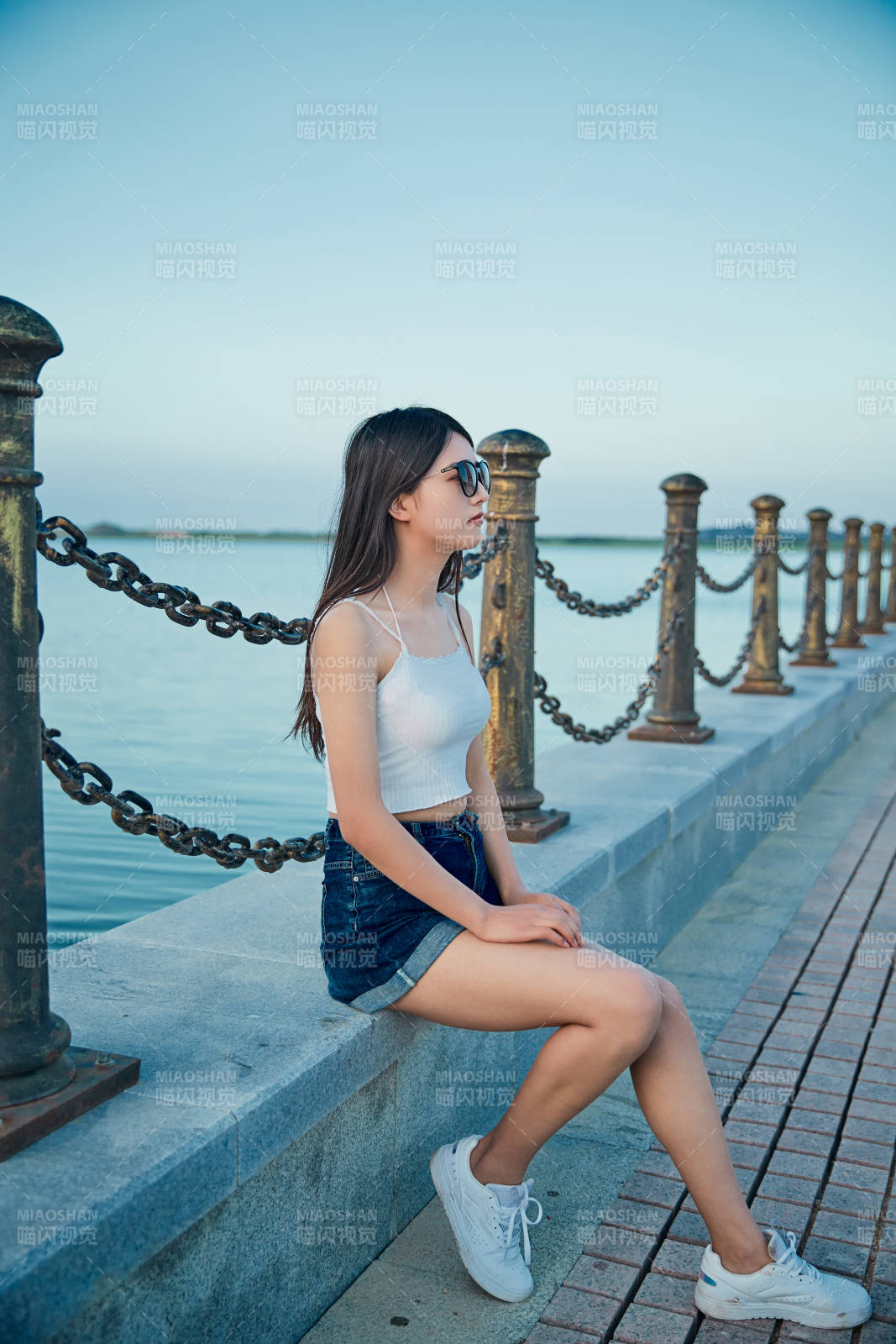 盛夏夕陽晚霞湖邊碼頭看風景的少女