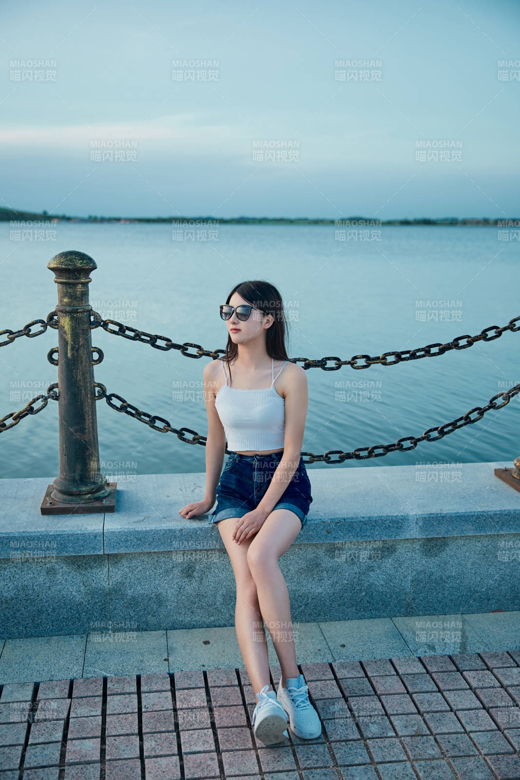 盛夏夕陽晚霞湖邊碼頭看風景的少女