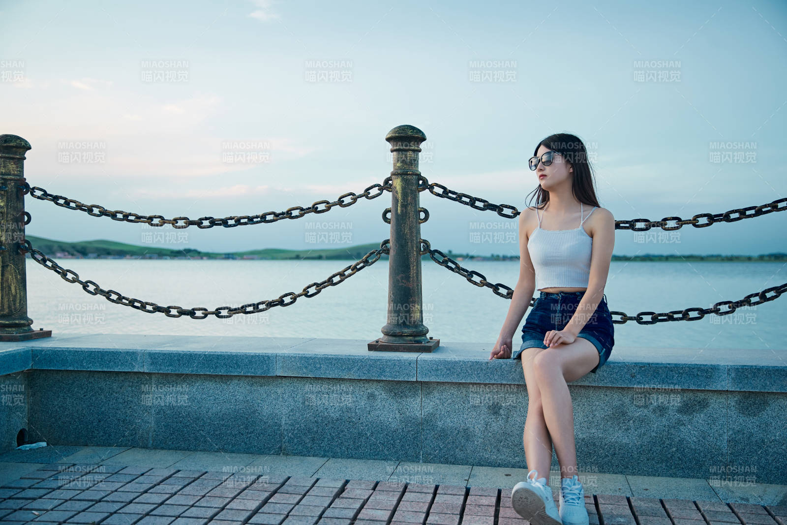 盛夏夕陽晚霞湖邊碼頭看風景的少女