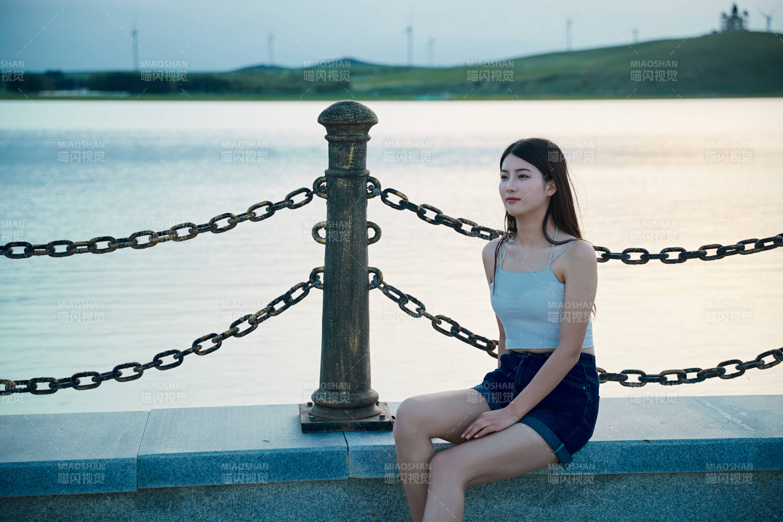 盛夏夕陽晚霞湖邊碼頭看風景的少女