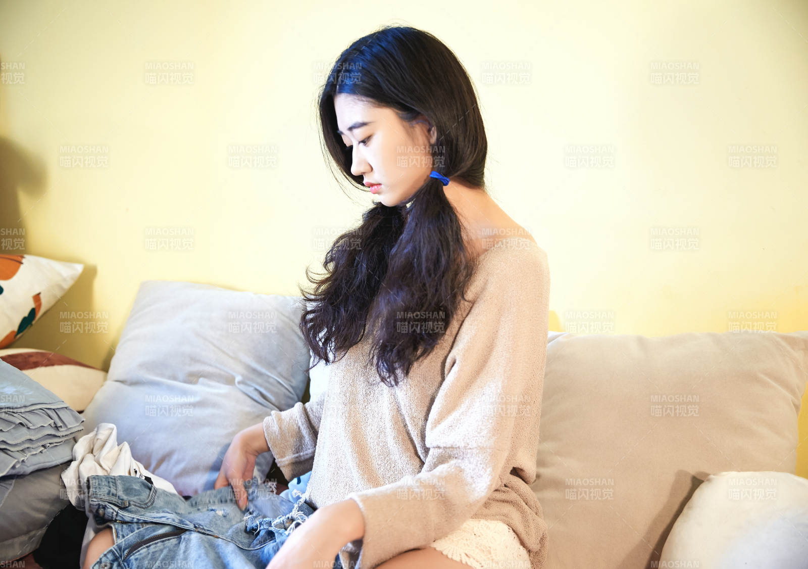 在沙發床上整理行裝的年輕亞洲女性
