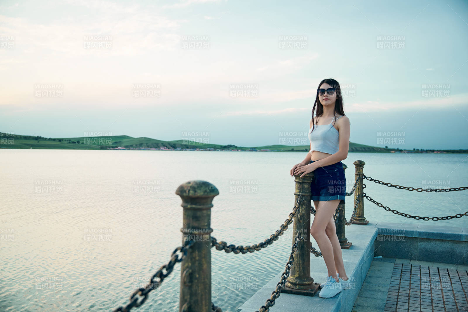 盛夏夕陽晚霞湖邊碼頭看風景的少女