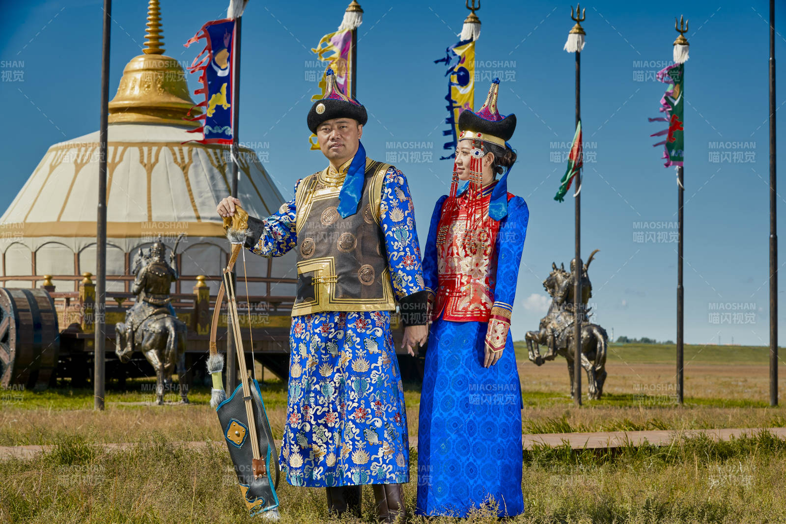 草原上蒙古包前穿蒙古族傳統服飾的年輕夫妻