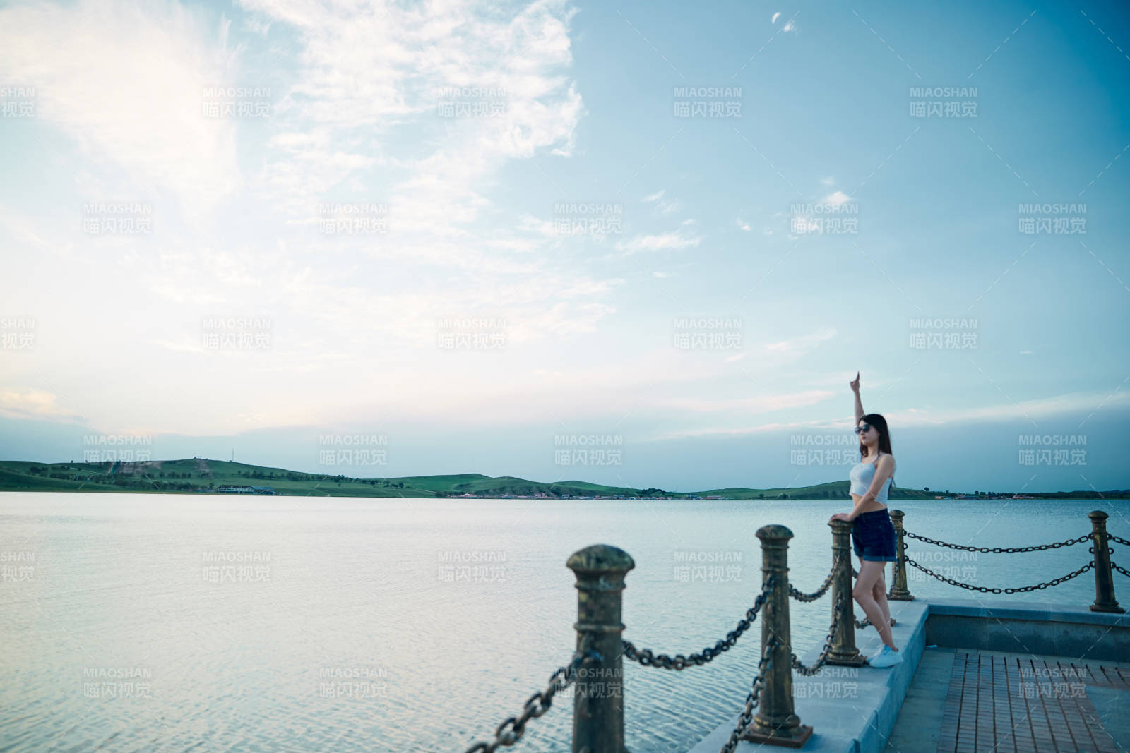 盛夏夕陽晚霞湖邊碼頭看風景的少女