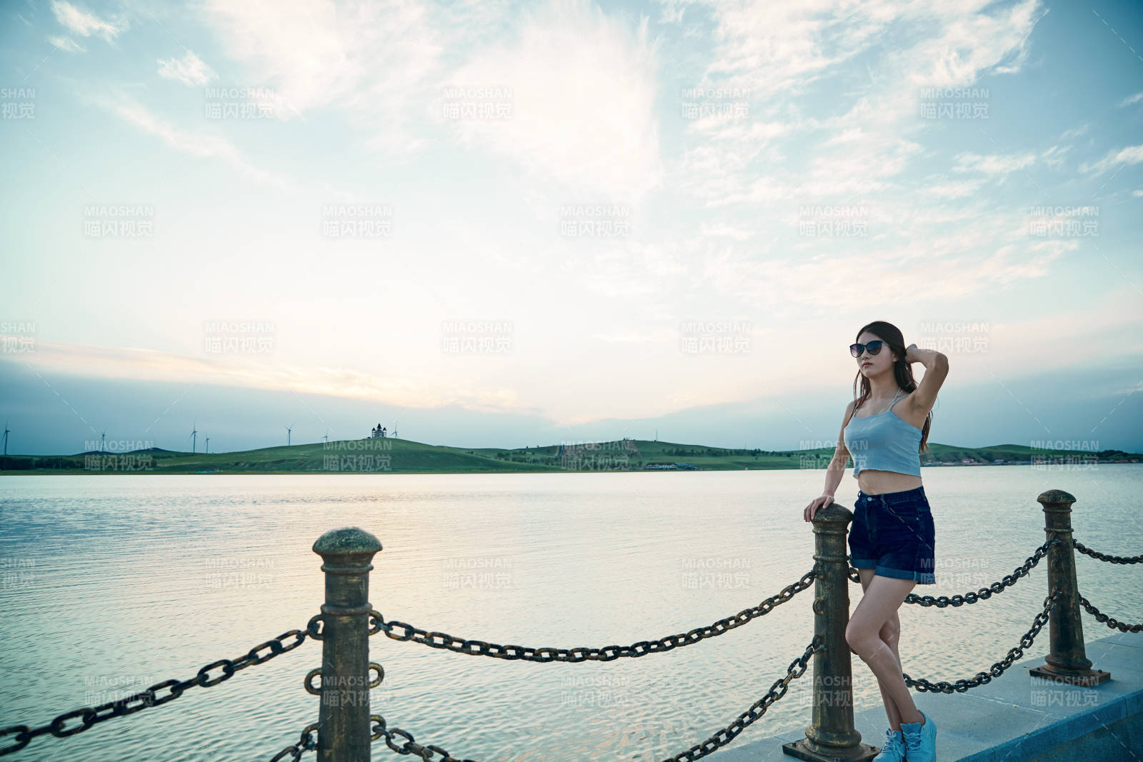 盛夏夕陽晚霞湖邊碼頭看風景的少女