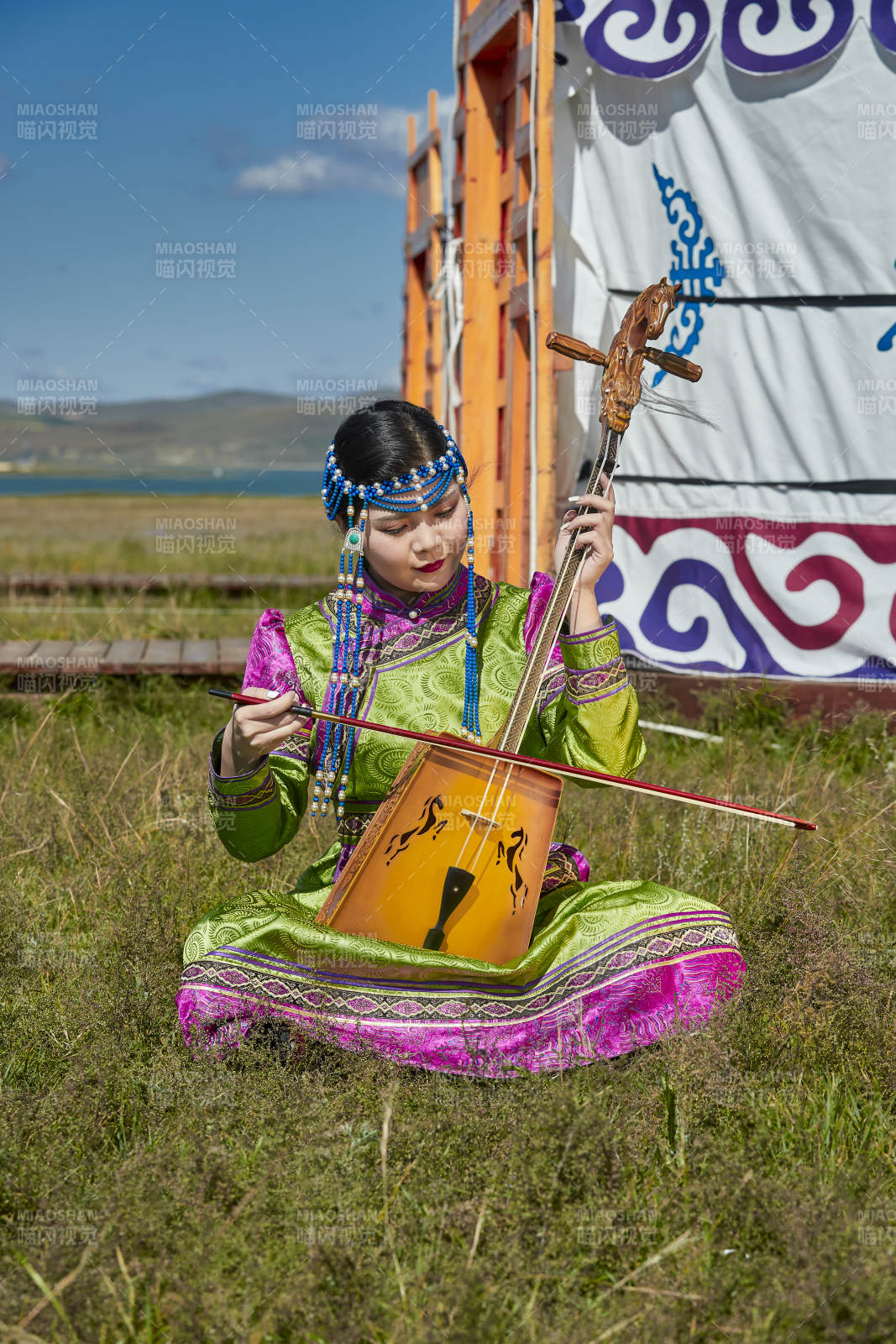 蒙古包前穿蒙古族服飾拉馬頭琴的蒙族女樂手