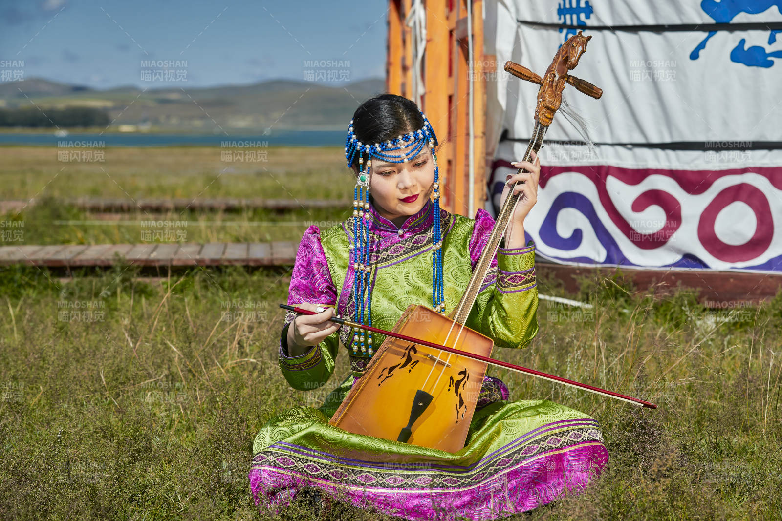 蒙古包前穿蒙古族服飾拉馬頭琴的蒙族女樂手