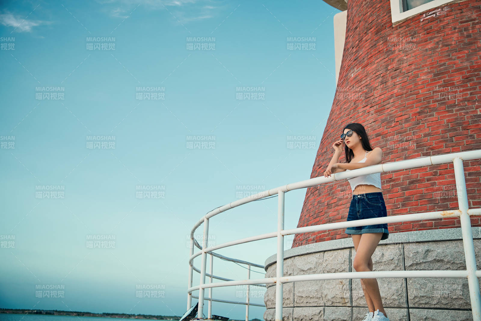 盛夏夕陽晚霞湖邊碼頭看風景的少女
